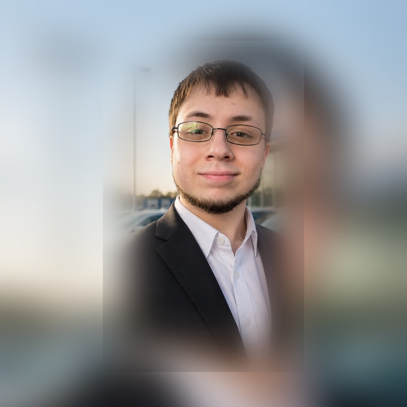 Headshot of Diego Gonzalez Alicata wearing a dark suit and glasses